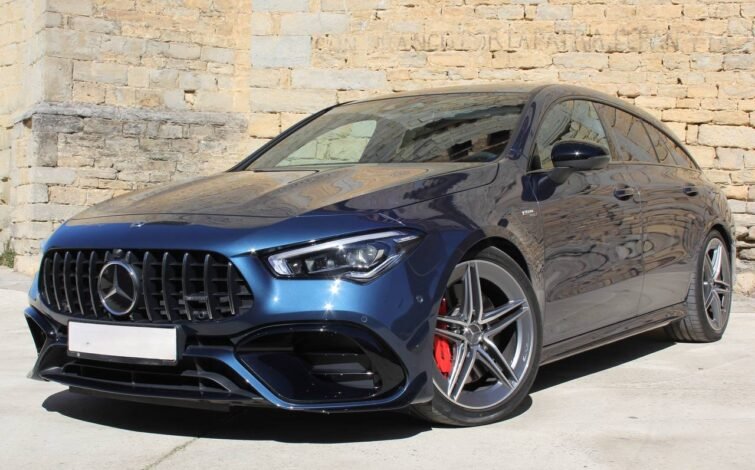 Vista frontal lateral derecha del Mercedes-Benz CLA 45 S AMG 4MATIC+ azul, enfocando las llantas deportivas, pinzas de freno AMG y detalles del diseño lateral.