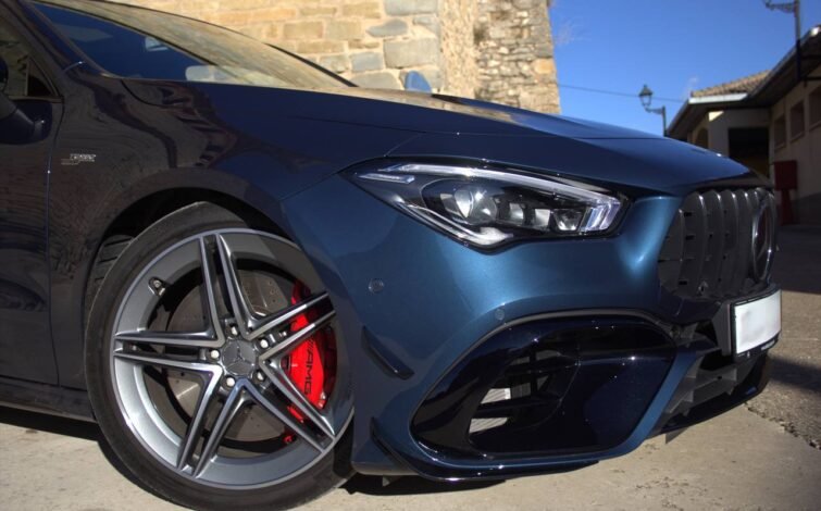 Detalle del frente del vehículo con enfoque en el faro LED y llanta AMG con pinza de freno roja, mostrando también el emblema "Turbo 4MATIC+".