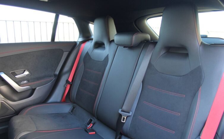 Asientos traseros deportivos del CLA 45 S AMG con tapicería en cuero y alcántara, costuras rojas y cinturones de seguridad en rojo.