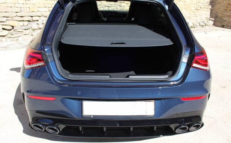 Maletero del CLA 45 S AMG con compuerta trasera abierta, mostrando el espacio de carga cubierto con tapa enrollable.