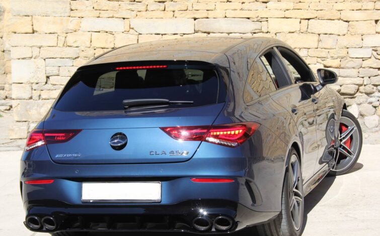 Parte trasera del CLA 45 S AMG desde una vista baja, mostrando luces encendidas, difusor y doble salida de escape cuádruple.