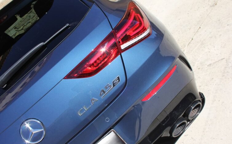 Parte trasera del Mercedes-AMG CLA 45 S en color azul, mostrando el emblema del modelo, luces traseras LED encendidas y doble salida de escape cuádruple.