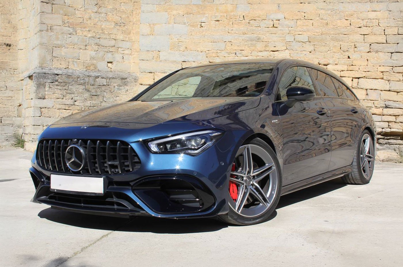 Mercedes CLA 45s AMG Shooting Brake 2023 en azul diablo – vista frontal en exterior de piedra natural.